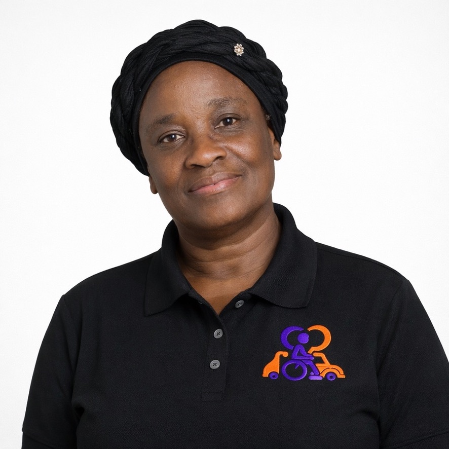 Dieula Deriza, CEO of Inspiring Mobility & Care Rides wearing black polo with embroidered orange and purple logo